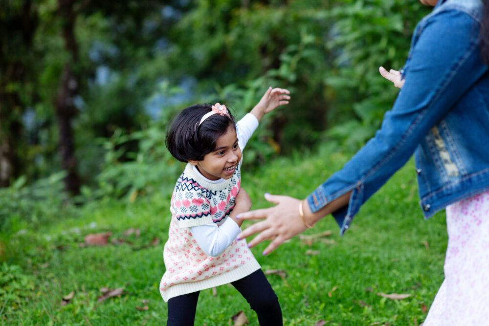 A girl runs towards a woman's outstretched arms.