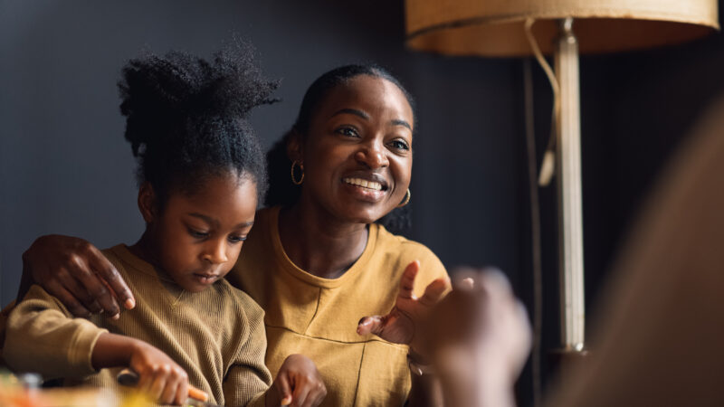 A woman and a girl share a meal.